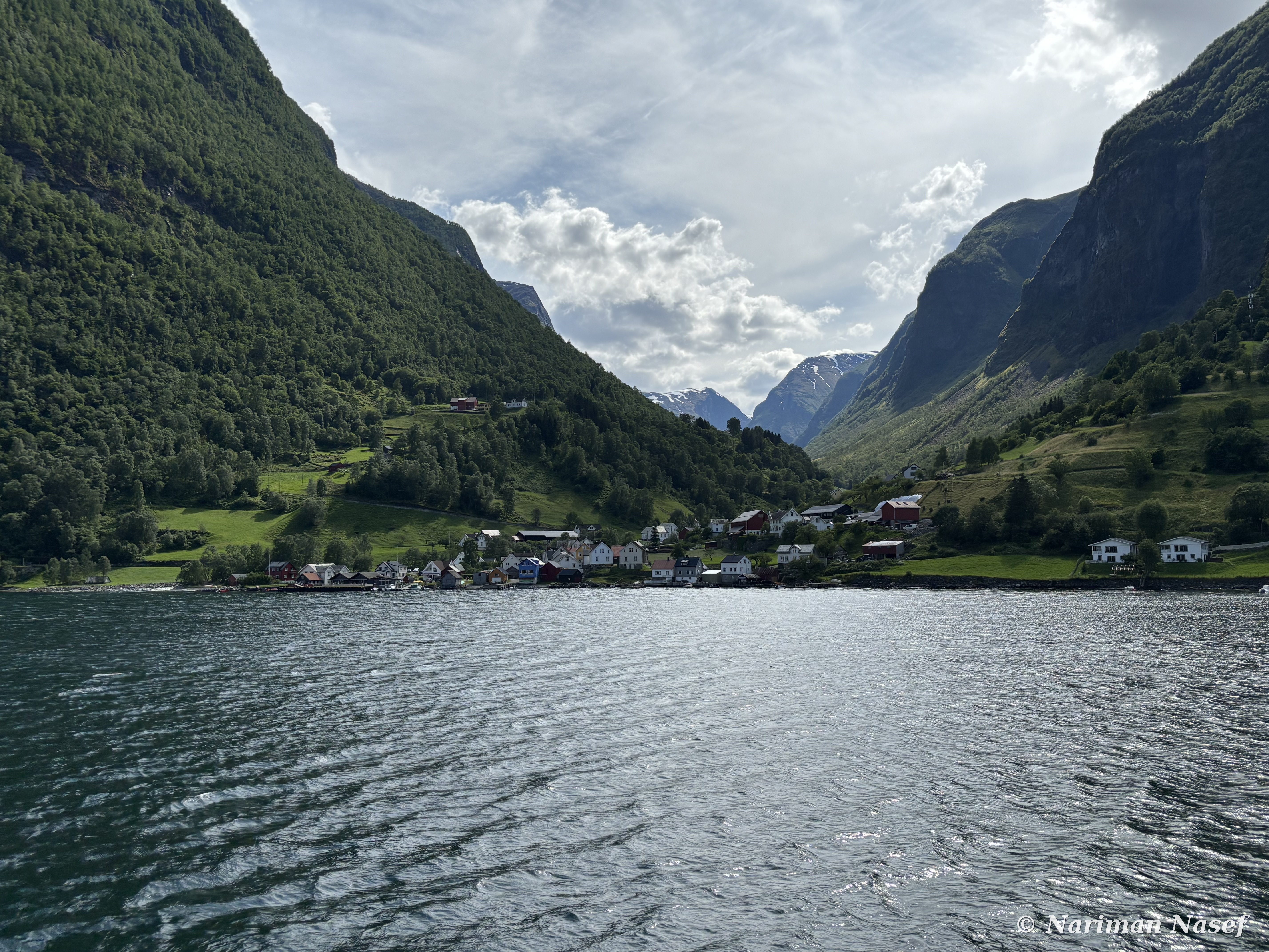Small fjord village beneath green slopes
